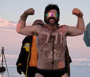 a expeditioner shaves "77th Casey" over the body hair of his chest