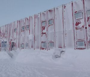 a photo of the red shed with a covered white snowed exterior