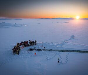 a view of the cut out sea ice looking north with the sun rising over the horizon