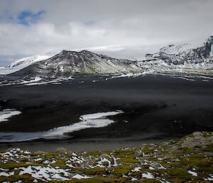 A snowy mountain with a lake in the foreground