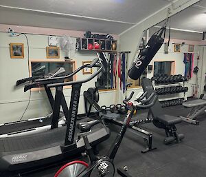 Before photo of station gymnasium, showing many weights benches close to all the cardio equipment