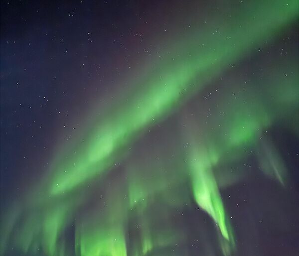 Casey station aurora australis pictured in the sky with arrays of color and stars - 18 June 2024