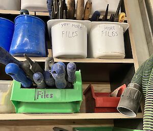 Workshop shelf at Mawson showing containers of tools including three containing hand files, marked Files, More Files and Yet More Files