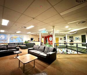 Large room with lounges and a coffee table and a staircase coming up