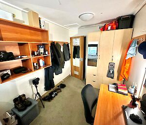Room with a desk, shelves and a wardrobe