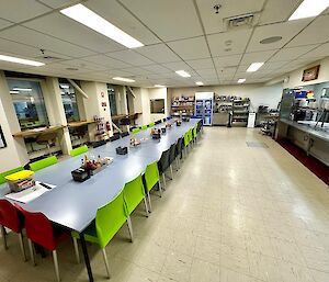 A large cafeteria with beige floor tiles and a long table