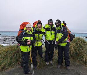 Four walkers stand smiling together