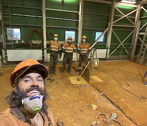 A team of men in high vis in a shed