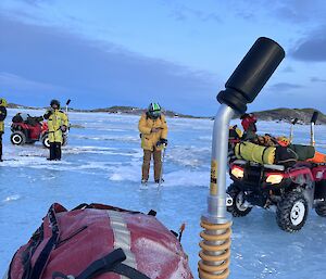 A group of people on the ice with quad bikes