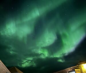 Print green aurora lights dance over the station buildings