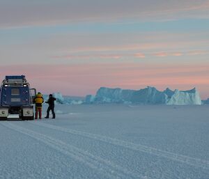 Dave and Jason preparing the drill on the sea-ice near Mawson. the colours are the pinks, purples and blues that signify a chilly mid-winters day