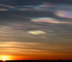Iridescent clouds above an orange sunset