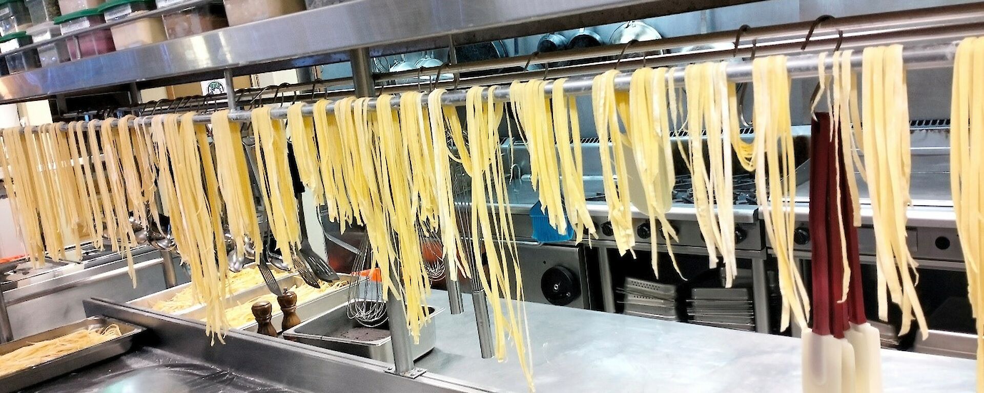 strings of pasta hanging over a rail