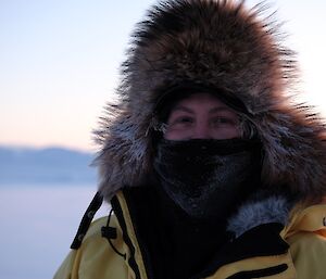 Expeditioner Peter Laughton wears cover mask and big wooly hat for a portrait taken on the sea ice during mid winter swim. A focused close shot with blurred backround