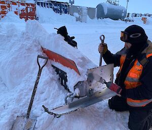 Peter Laughton is pictured fixing a machine part full of snow