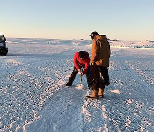 Two expeditioners drilling the sea-ice to determine thickness near the Forbes Glacier