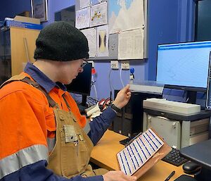 a Bom observer analyes the data from the monitor and fills out a record sheet to determine the balloons tradjectory