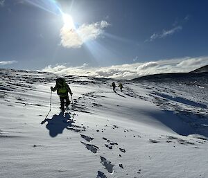 Three people walking across the plateau in deep snow