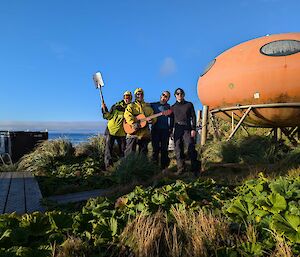 A group stands in front of a round orange melon hut
