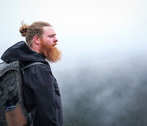 a side on portrait of an expeditioner in Hobart with green cloudy background