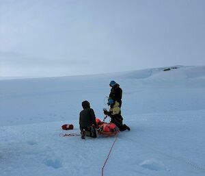 Two people on a snowy slope doing search and rescue training