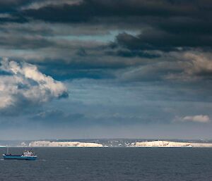 Looking across the sea towards some white cliffs.  A fishing vessel sits in the sea infront.