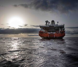 A ship heading off towards the horizon leaving patters and swirls in its wake