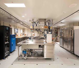A room with stainless steel sinks and benches, water sampling equipment and fridges