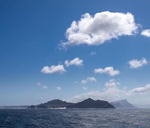 Looking across the water towards some land with blue sky above