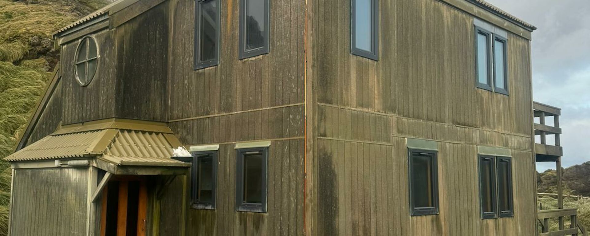Brown two-storey building with a dirt front yard