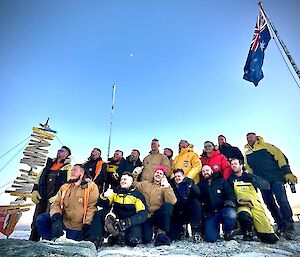 a group of the casey community stand proudly and uniformly below the Casey sign and Australian flag in support of a mental health charity fundraiser