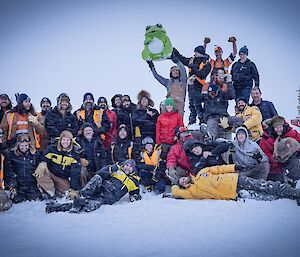 a group photo of the whole station during mid-winter with the Australian flag in the background flying high