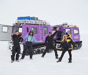 4 expeditioners stand in front the vibrantly contrasted Haglund vehicle against a white abyss