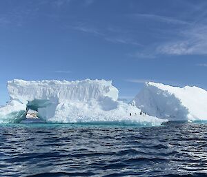 A remarkable image taken aboard a inflatable rubber boat showcasing the uniqueness of iceberg formation in the water. penguins making use of the floating structure
