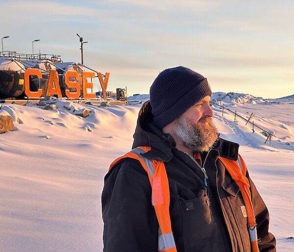 James standing in the foreground gazing into the bay with the Casey sign in the background