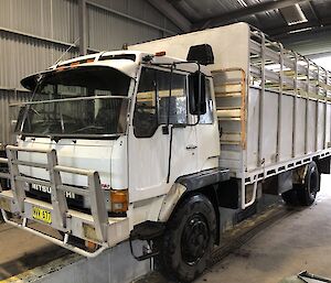 A photo of James’ fathers old truck. a large white cage bedded truck