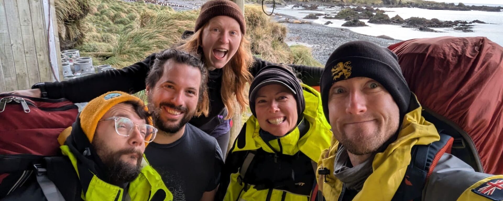 Selfie of five expeditioners on porch of field hut