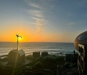 Smartie hut on the edge of the water, with sunrise in the distance