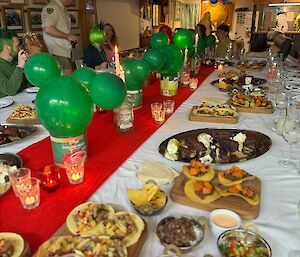 Large dinner table dressed for Mexican fiesta and laden with Mexican food