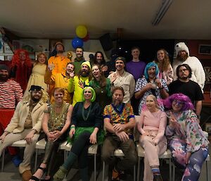 Expeditioners in clothes all of a single colour, stand in group in 'rainbow' order