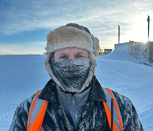 a close up portrait of Andrew with a frosty covered face after prolonged outside work in cold temperature