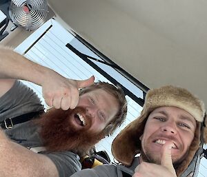 a self captured image of two expeditioners in a vehicle before departing out to retrieve fuel
