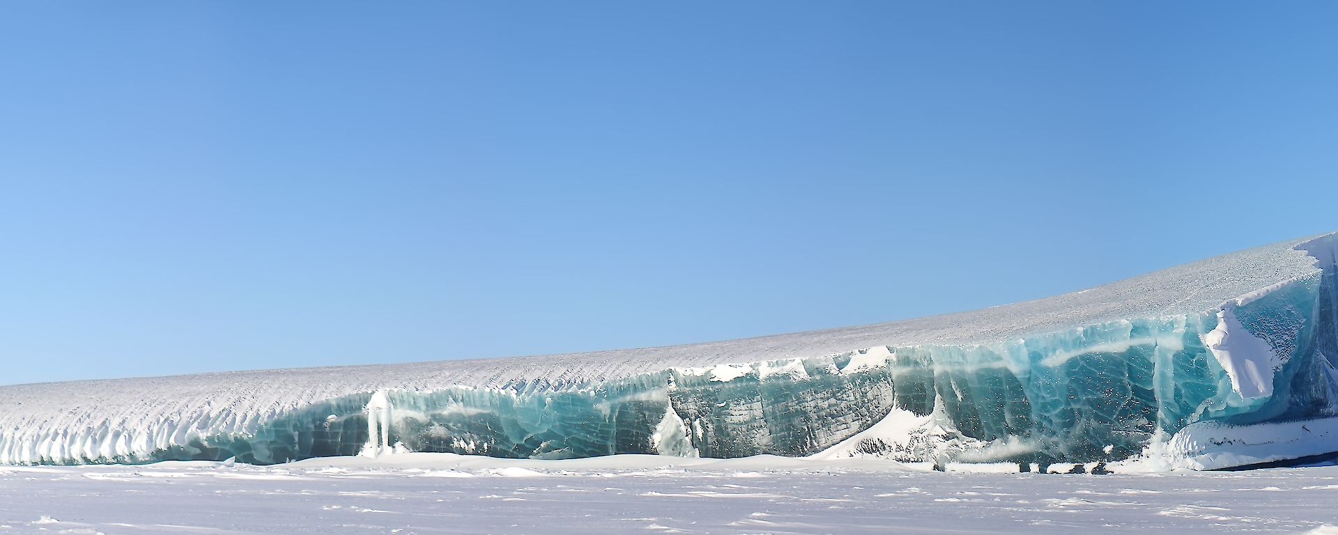 A large jade coloured iceberg trapped within the sea ice to the west of Mawson