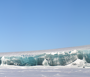 A large jade coloured iceberg trapped within the sea ice to the west of Mawson