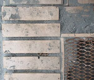 Looking down on patchwork of walkways around station - timber, metal grate and sand