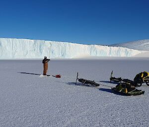 An expeditioner drilling into the sea-ice to determine thickness