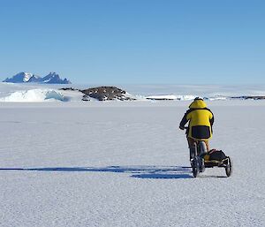 Dave biking off over the sea ice towing a trailer with his safety gear