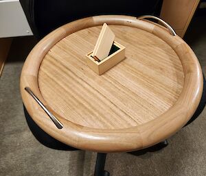 a circular timber constructed tea tray and tea bag box