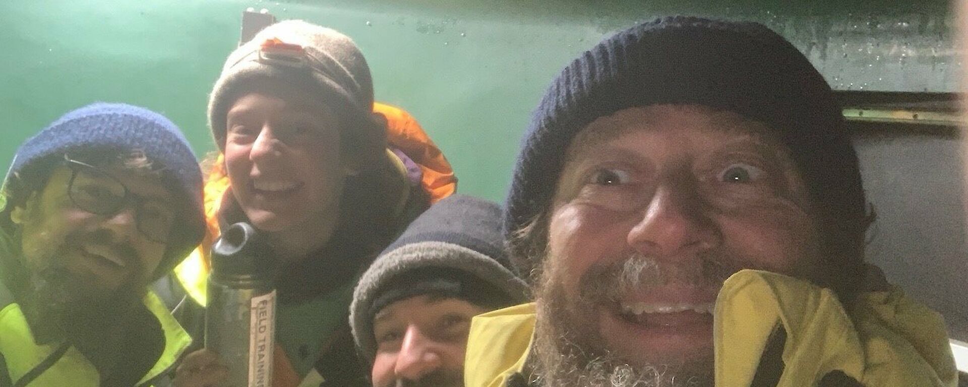 Selfie of four people inside the Water Tank Hut that is the Channel 21 Repeater Hut