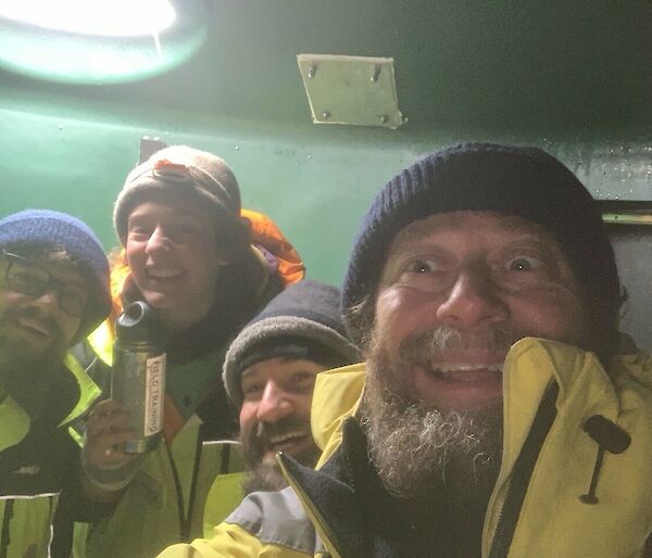 Selfie of four people inside the Water Tank Hut that is the Channel 21 Repeater Hut